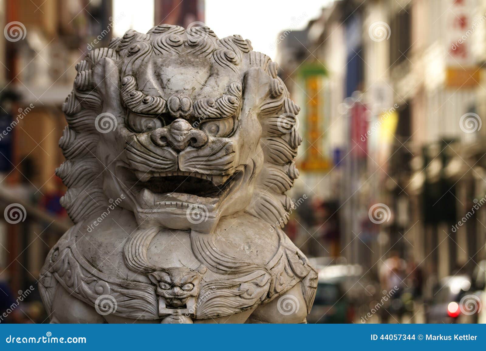 China-Stadt 1. Schließen Sie oben von der Löwestatue in Stadt Antwerpens China mit chinesischen Speichern und von den Werbeschildern im Hintergrund