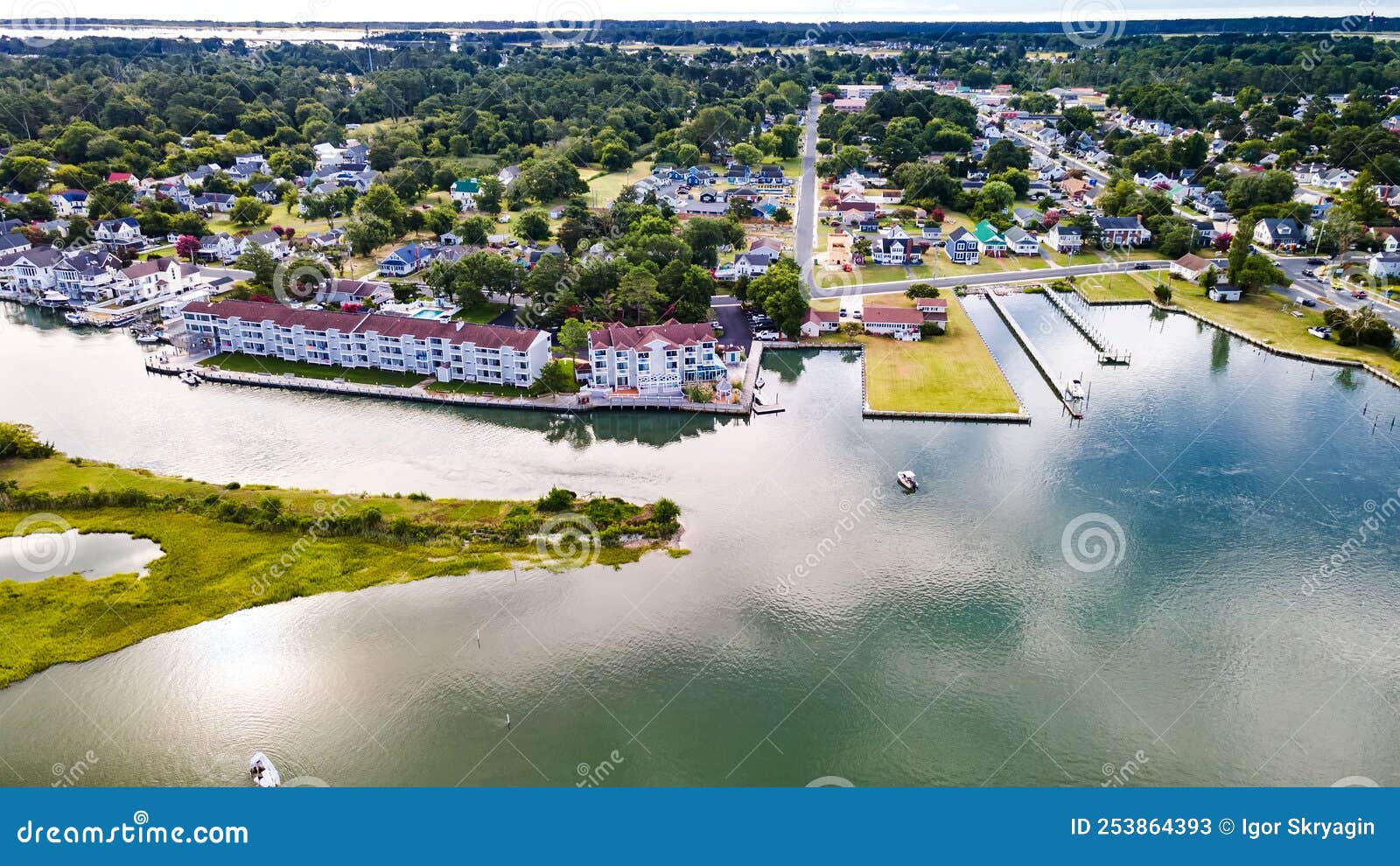 chincoteague island, marinas, houses and motels with parking lots. road along the bay. drone view