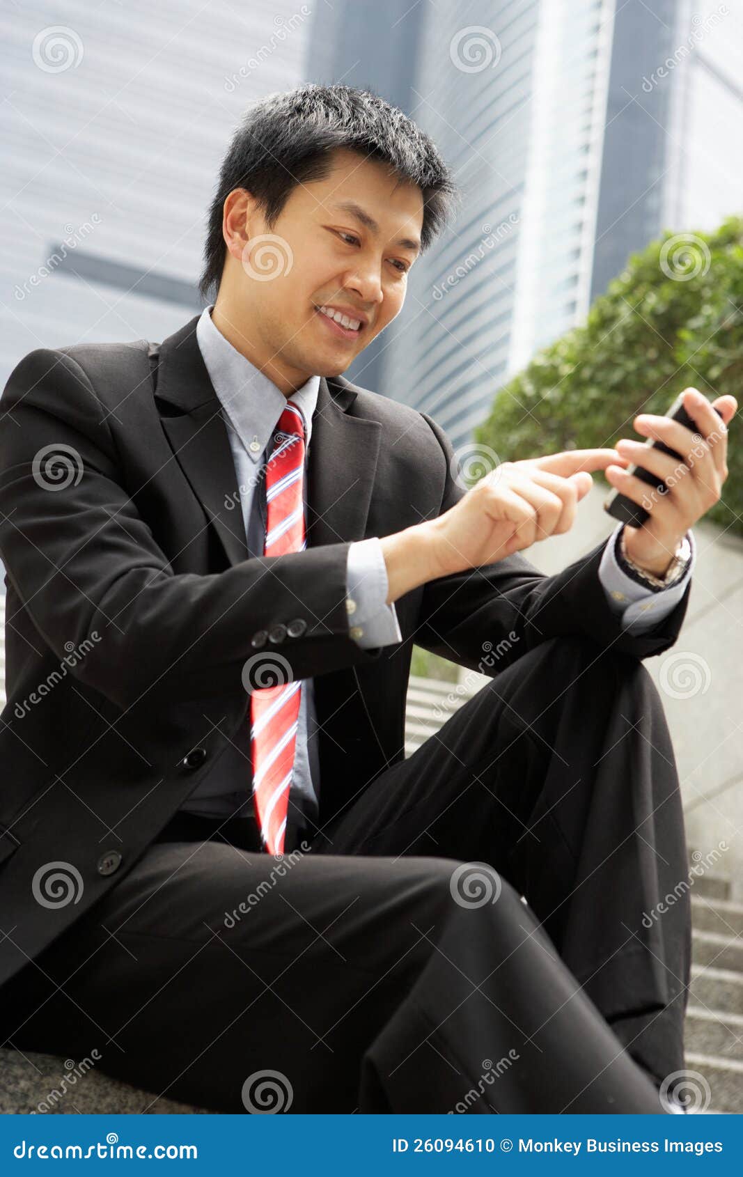 chinese businessman dialling on mobile phone