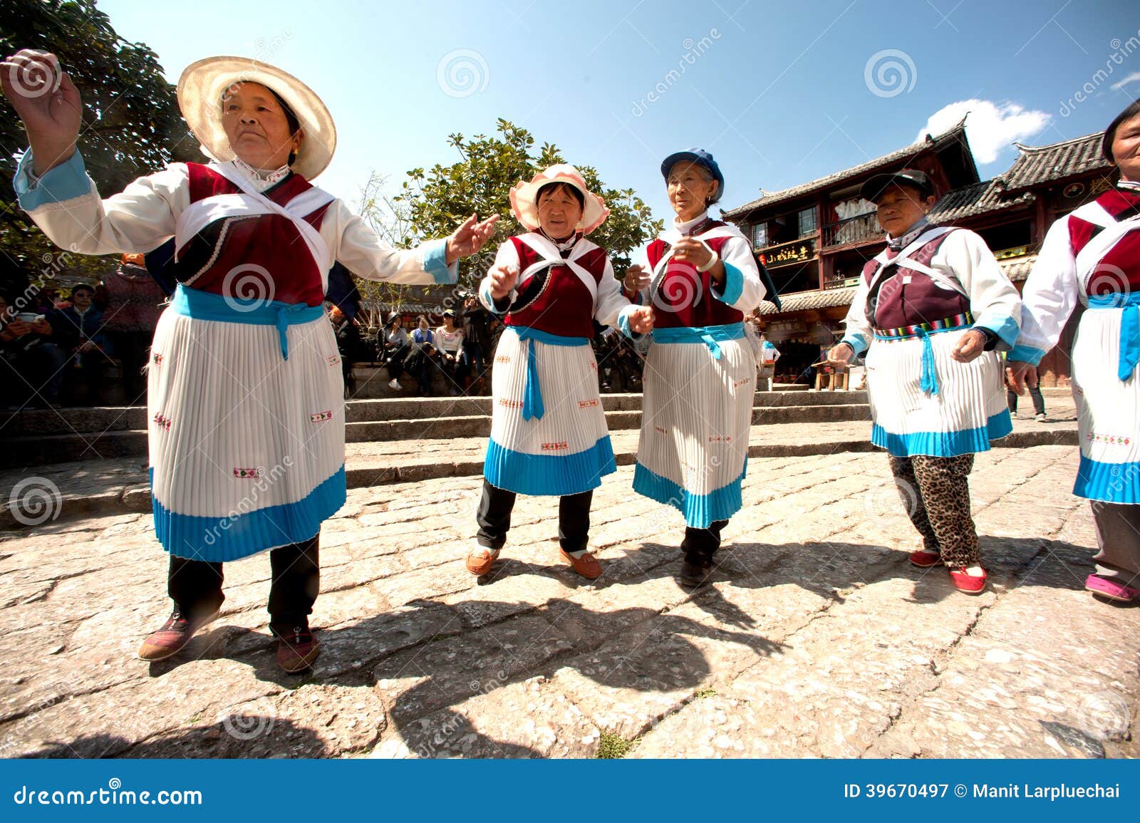 Chinese Naxi old woman performing a dance. LIJIANG,CHINA-MARCH 17:Naxi people do the traditional dance at Sifang square the center of Lijiang Dayan Old Town on March 17,2014 of Lijiang,Yunnan province,Southwestern of China The Lijiang is a tourist city of China.