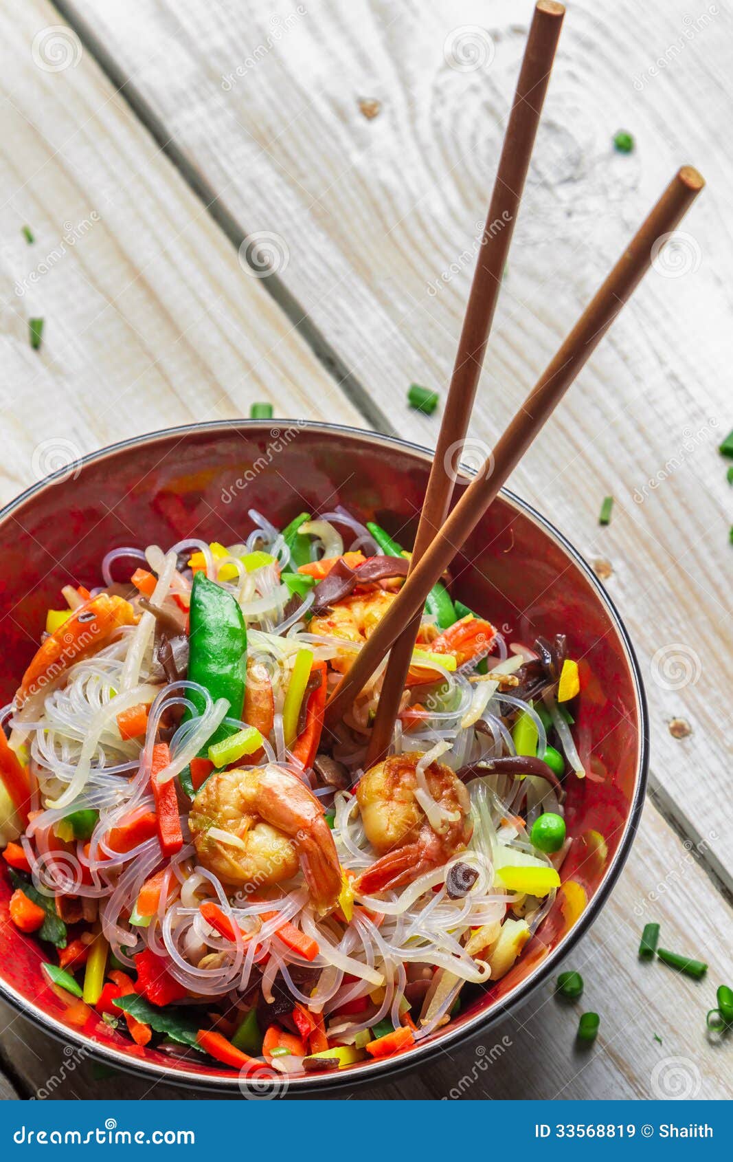 Chinese vegetables with pasta and shrimp on old wooden table