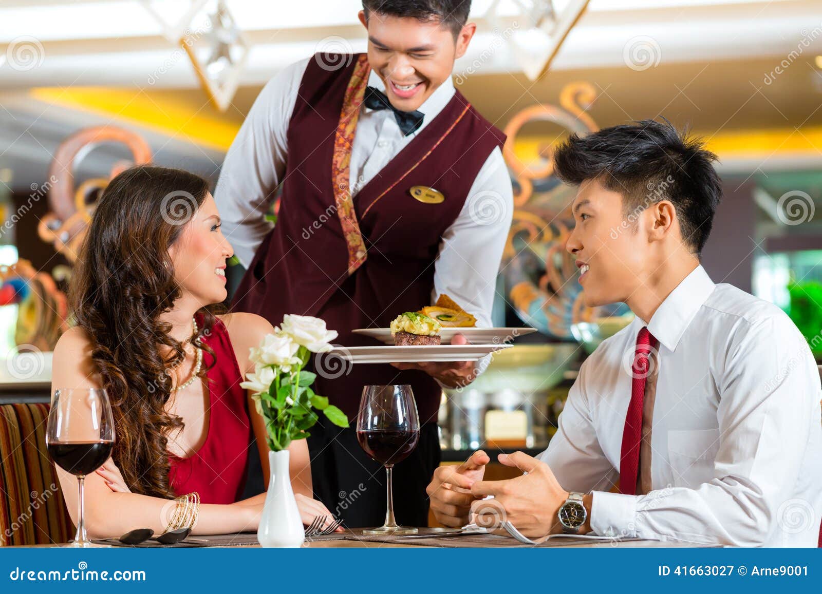 chinese waiter serving dinner in elegant restaurant or hotel