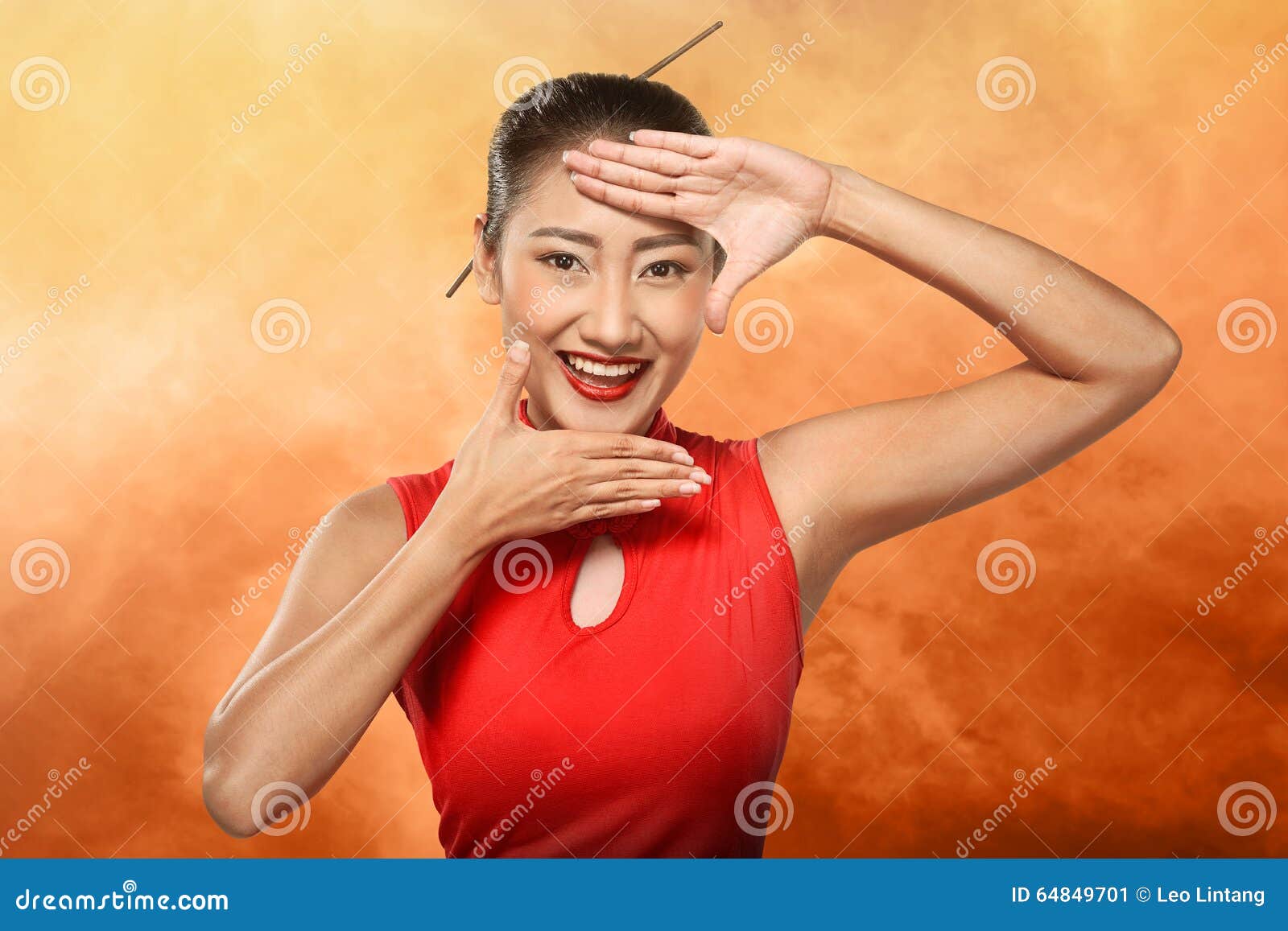 chinese woman in cheongsam dress framing her face with hand