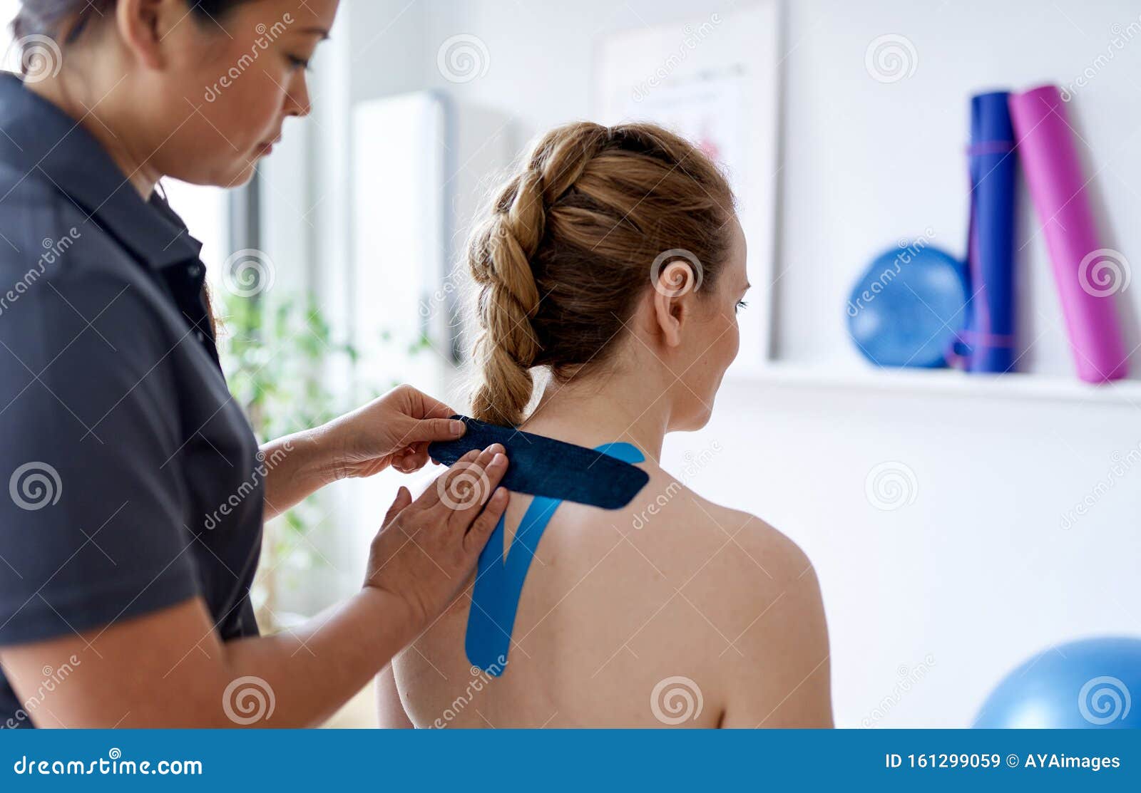Chinese Woman Massage Therapist Applying Kinesio Tape To The Sho Stock