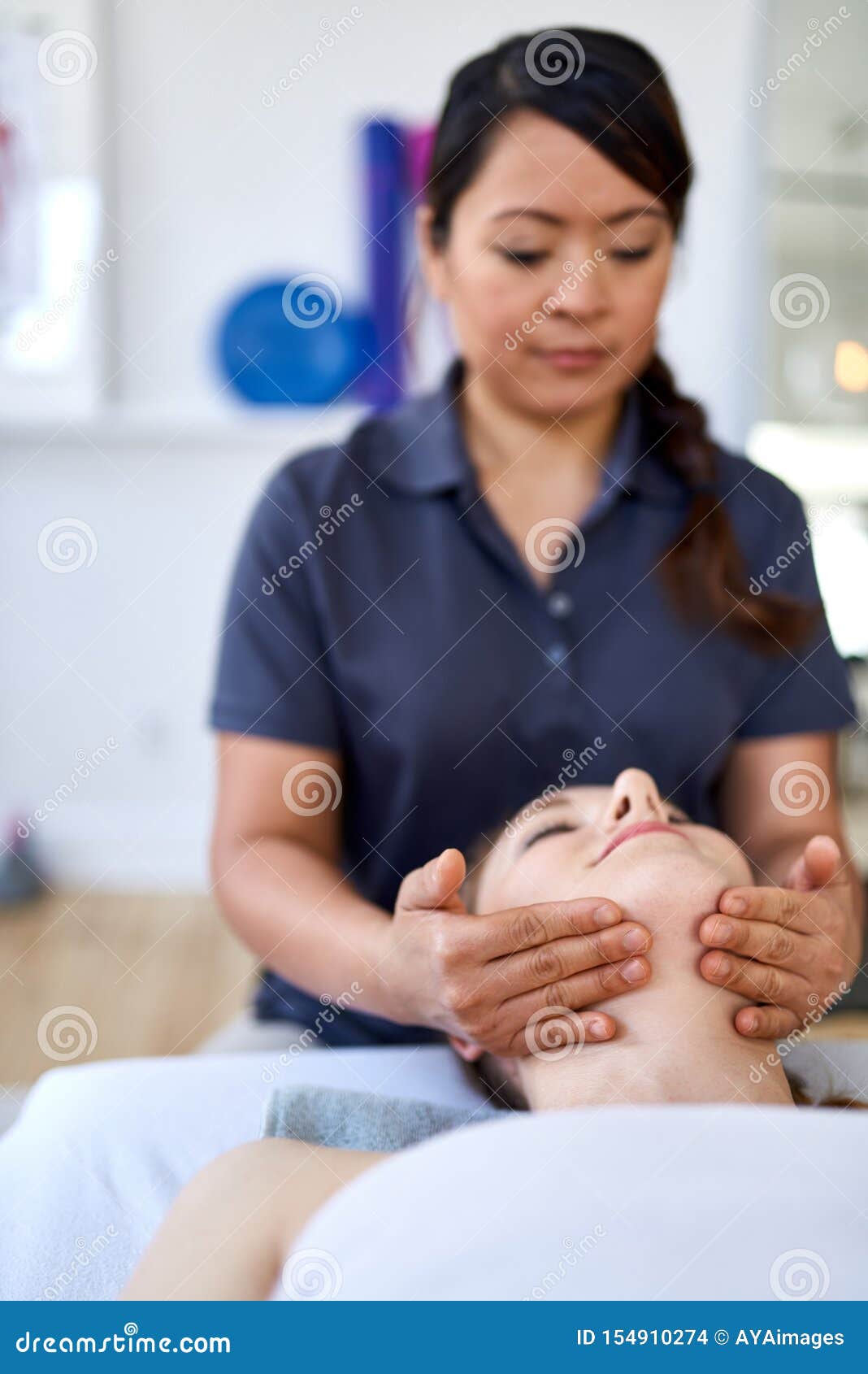 Chinese Woman Massage Therapist Giving A Treatment To An Attractive