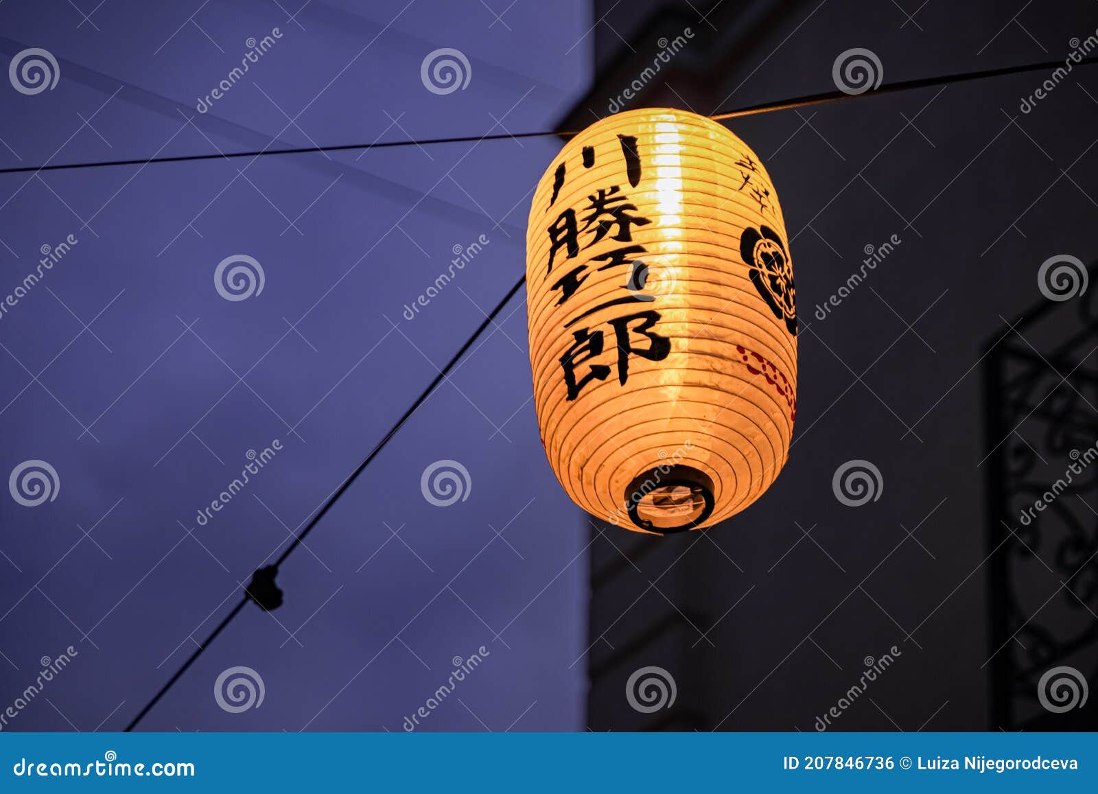 A Yellow Chinese Lantern Lights Up the Street in the Evening Stock