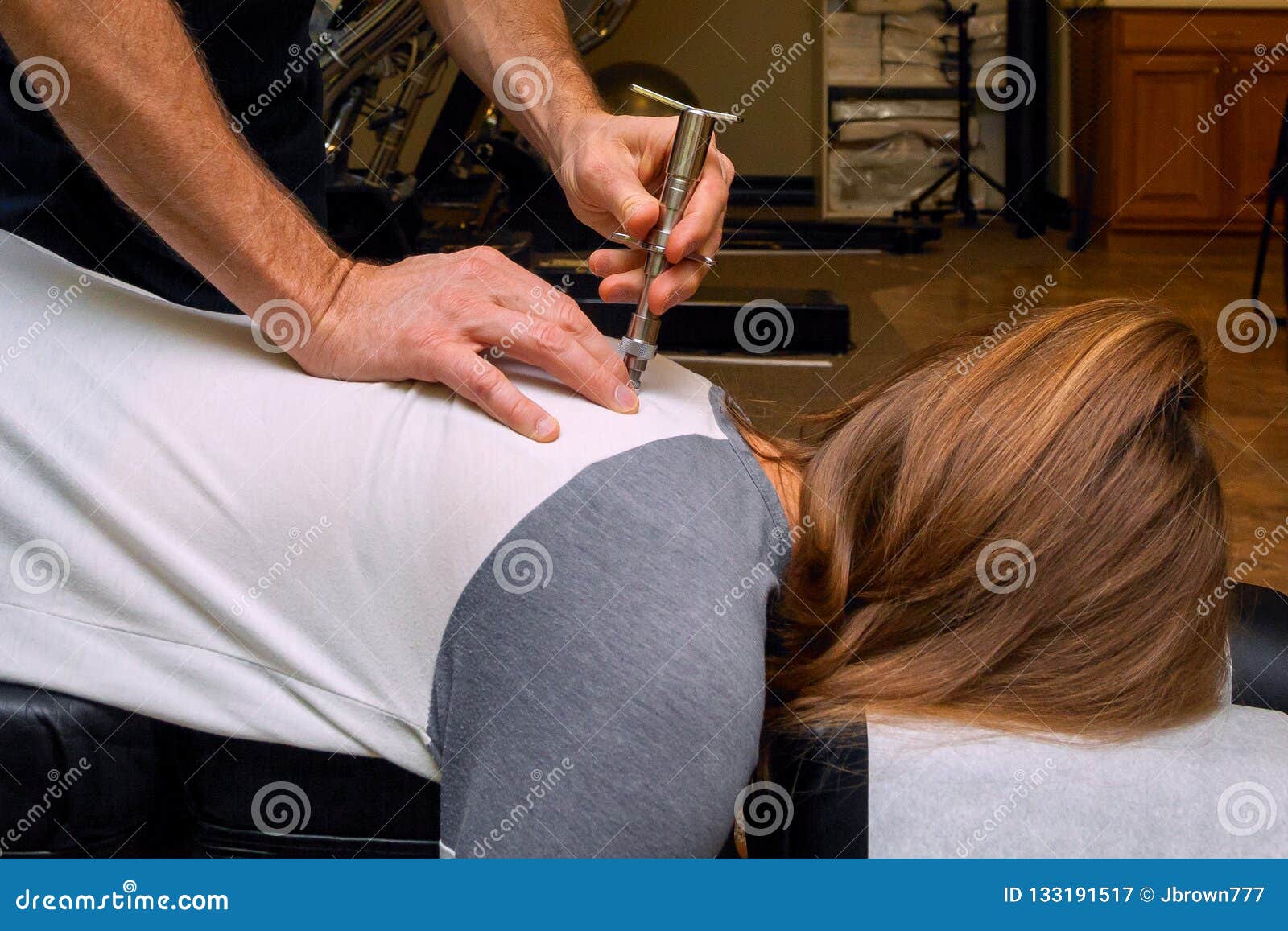 chiropractor uses an integrator on the back of a young girl