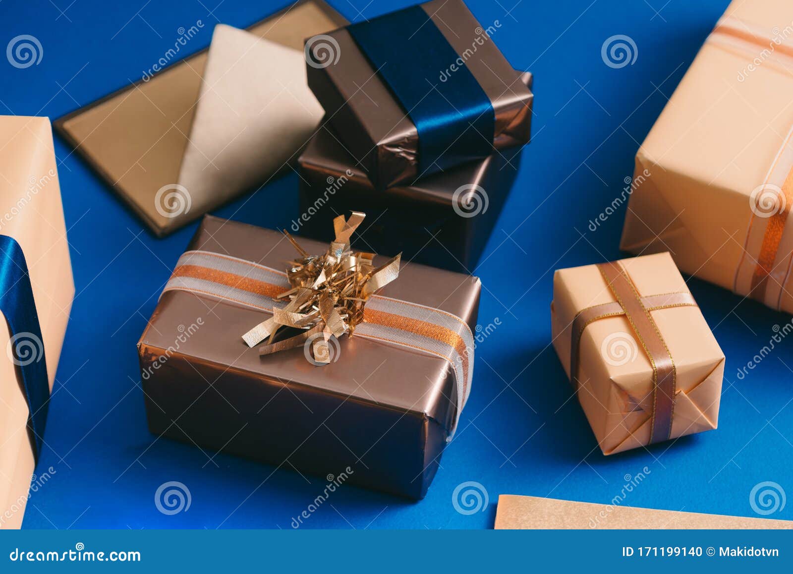 chirsmas concept with gold boxes, envelope, wreath on blue background