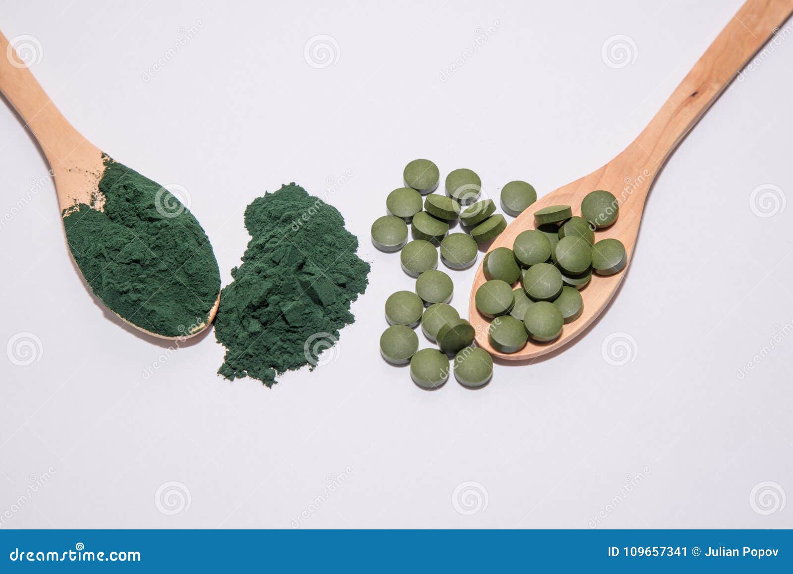 Chlorella Tablets and Spirulina Powder on Two Wooden Spoons Stock Image