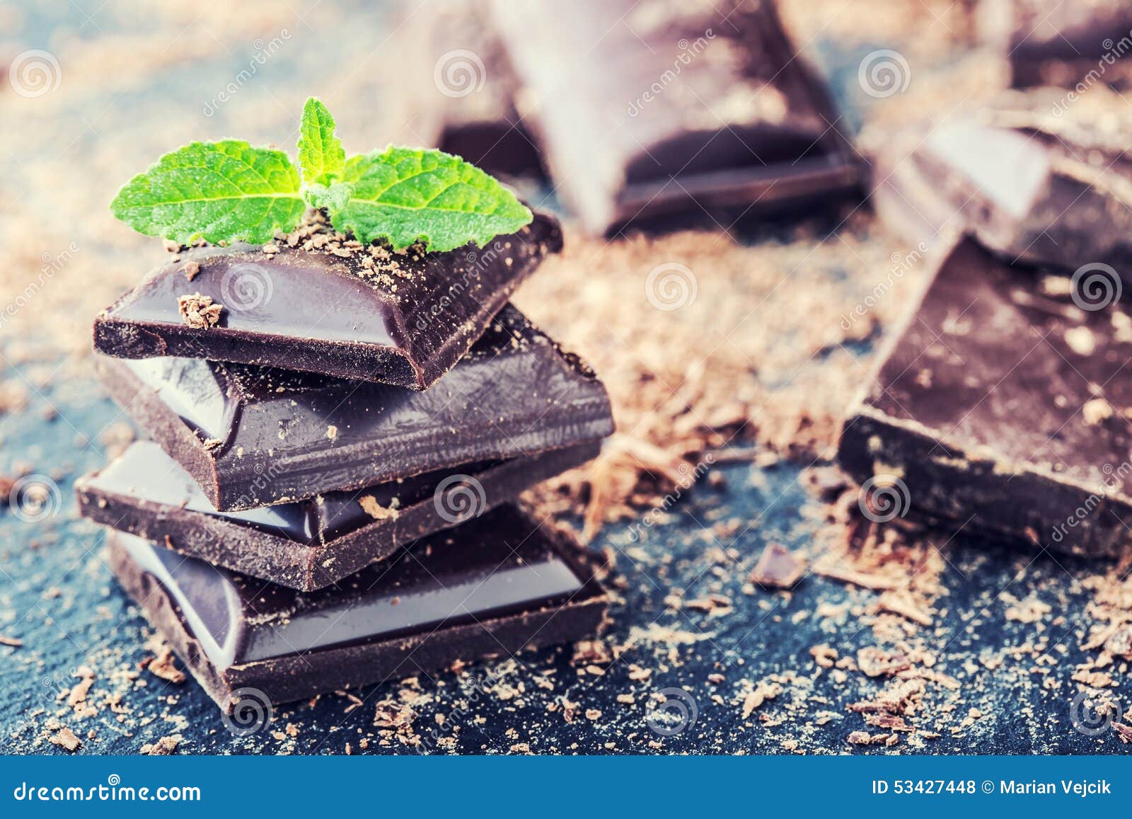 chocolate. black chocolate. a few cubes of black chocolate with mint leaves.