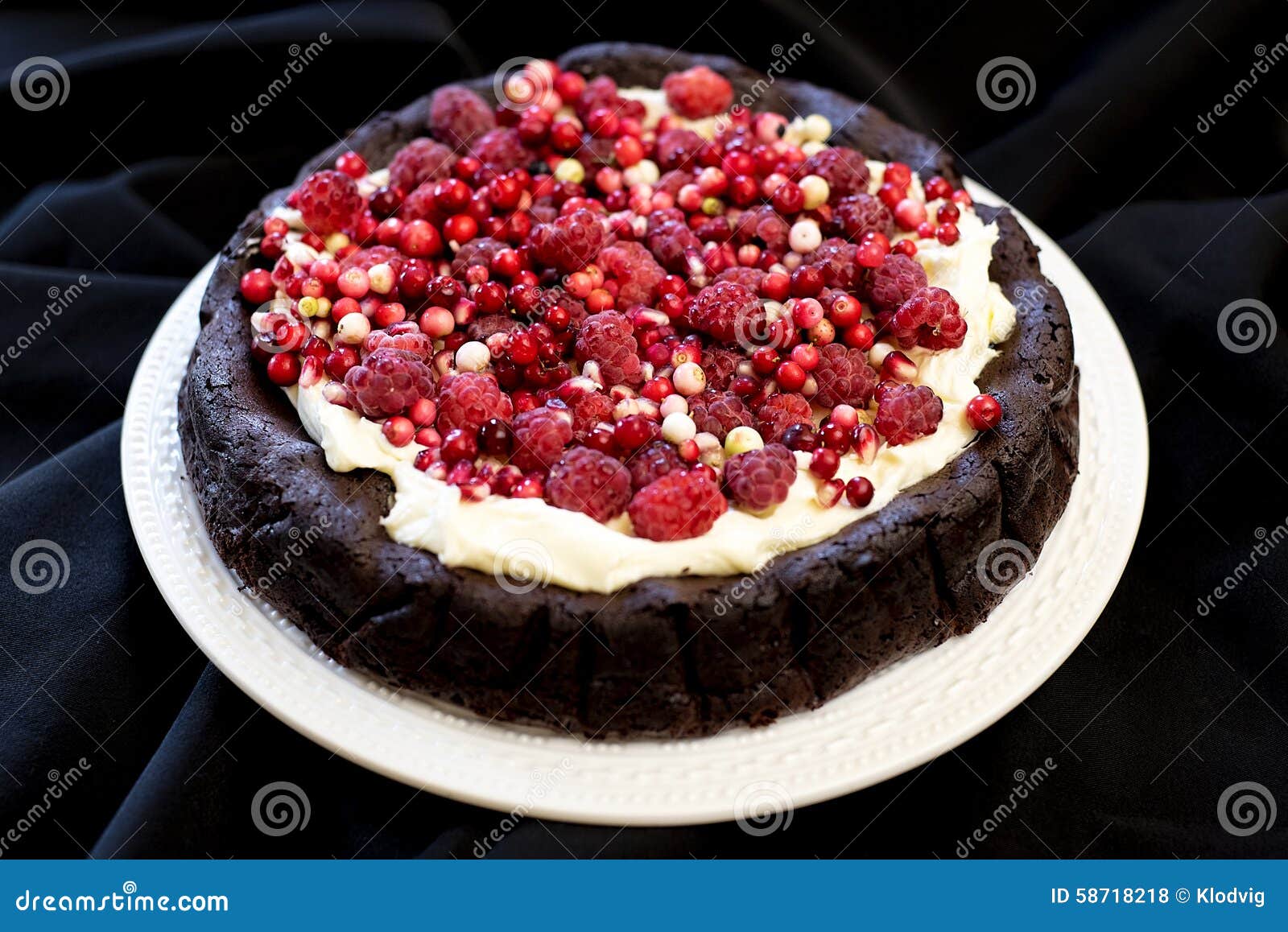 Chocolate cake with red fruits and cream. A dark chocolate cake with cream and red fruits on top.