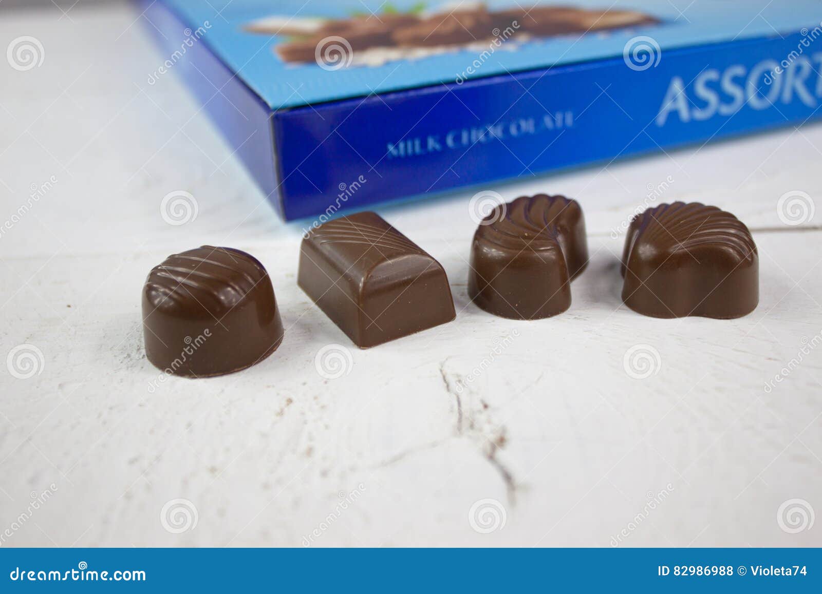 Chocolate Candy with Blue Chocolate Box on White Wood Stock Photo