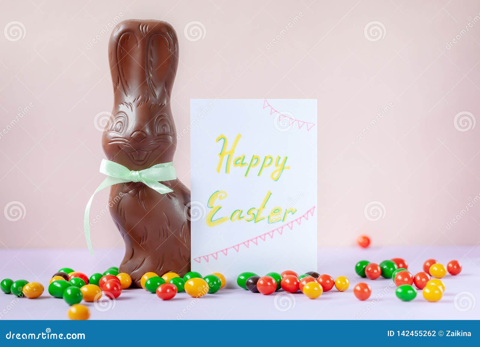 Chocolate Easter Bunny with Card on Pink Background Happy Easter