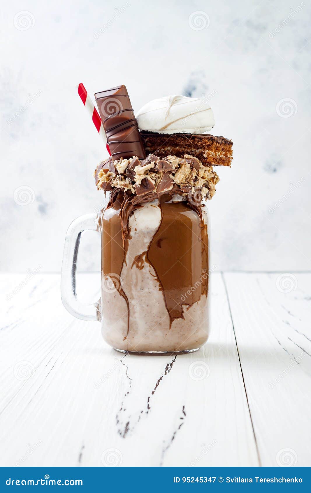 chocolate indulgent exreme milkshake with brownie cake, marshmallow and sweets. crazy freakshake food trend.