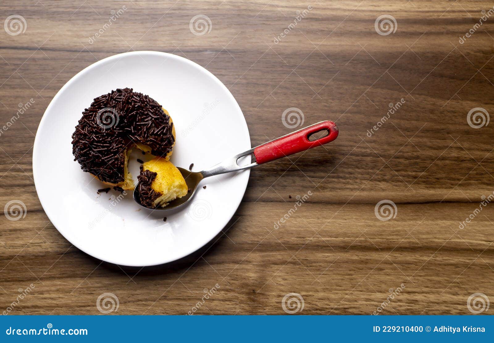 chocolate meses doughnut with spoon on white plate