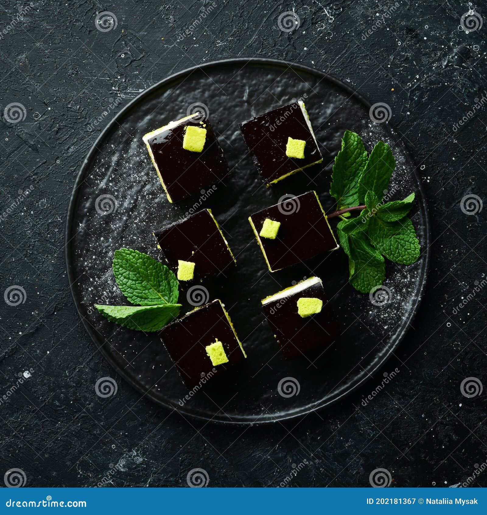 Chocolate Mousse Dessert Opera on a Black Plate with Mint. Top View
