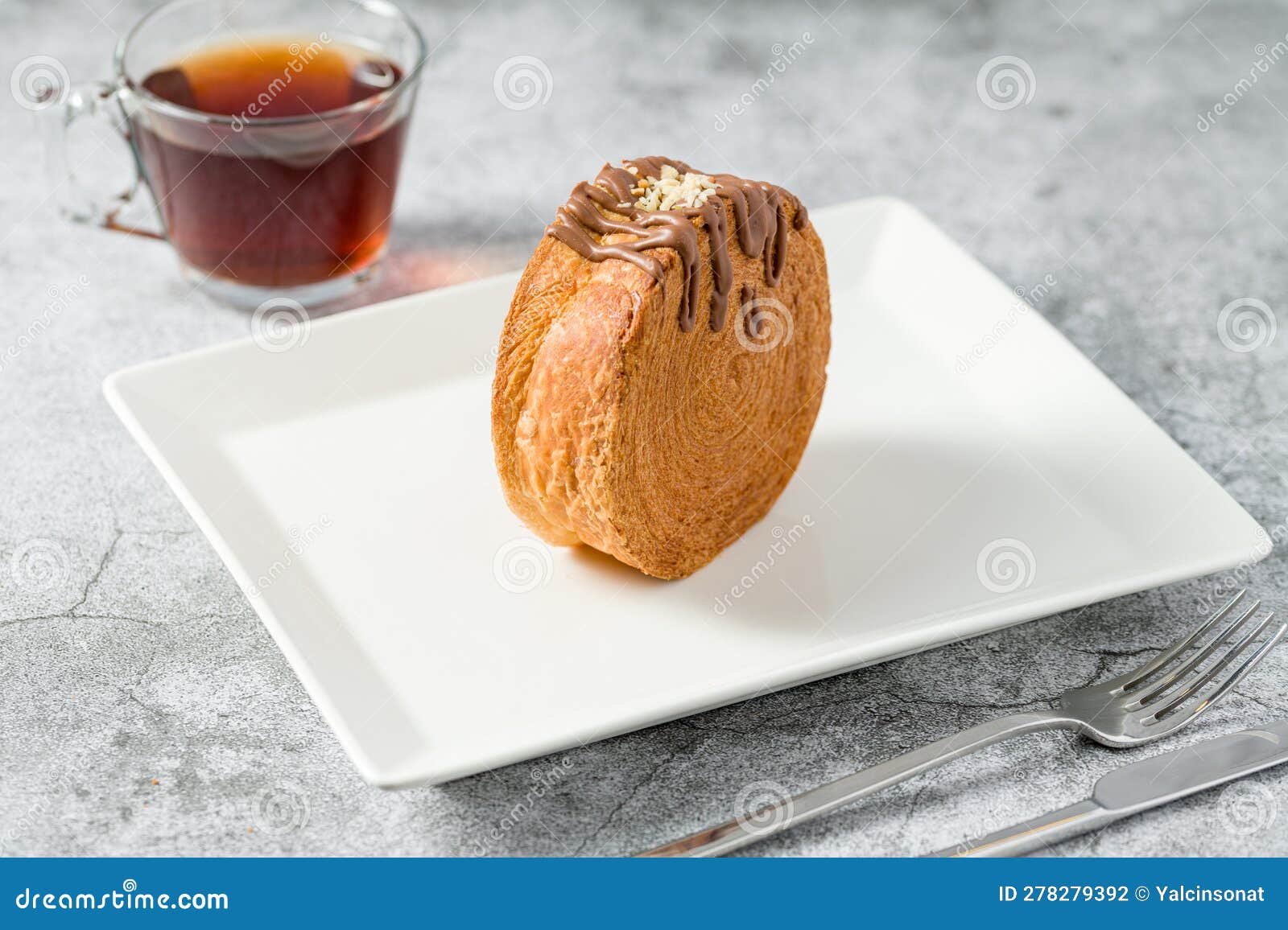 Chocolate New York Roll or Round Croissant with Tea on Stone Table