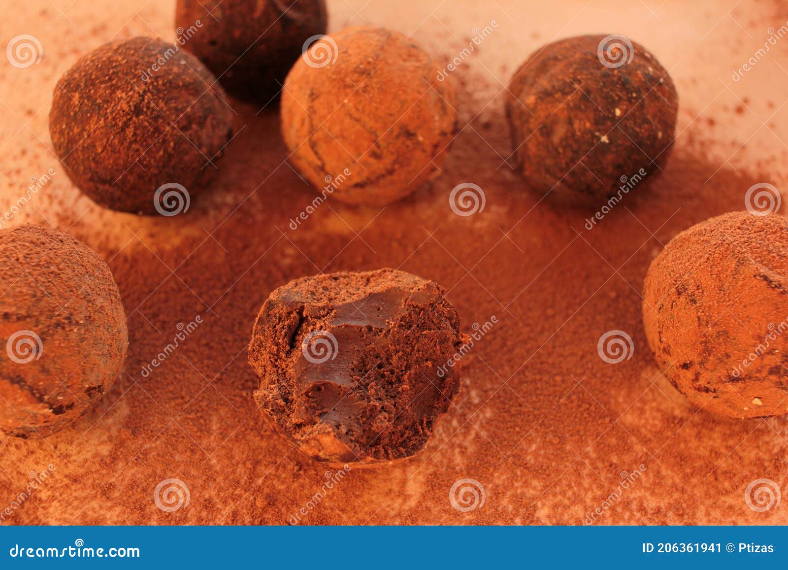 chocolate truffles, cocoa powder and cinnamon sticks on a craft paper background.