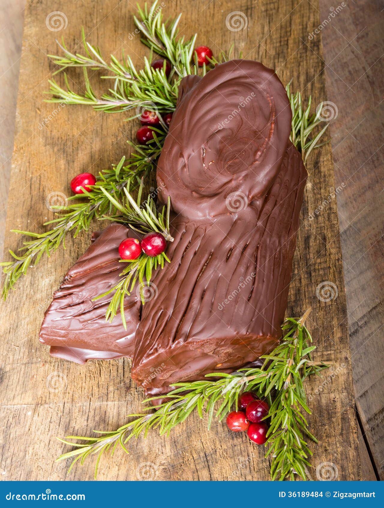 Chocolate Yule log with cranberries. Chocolate Yule log with green branches and cranberries