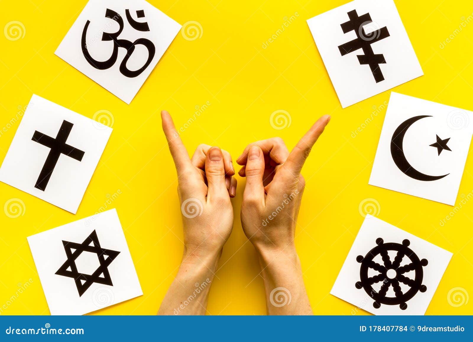choose religions concept. hands point on christianity, catholicism, buddhism, judaism, islam s on yellow