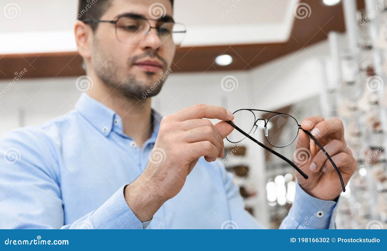 Portrait of Serious Young Man Choosing Spectacles Stock Photo - Image ...