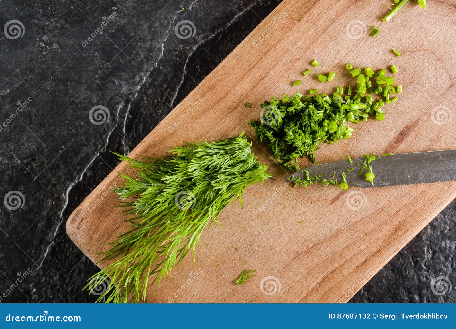 Chopped Bunch of Fresh Dill on a Black Stone Background. Stock Photo