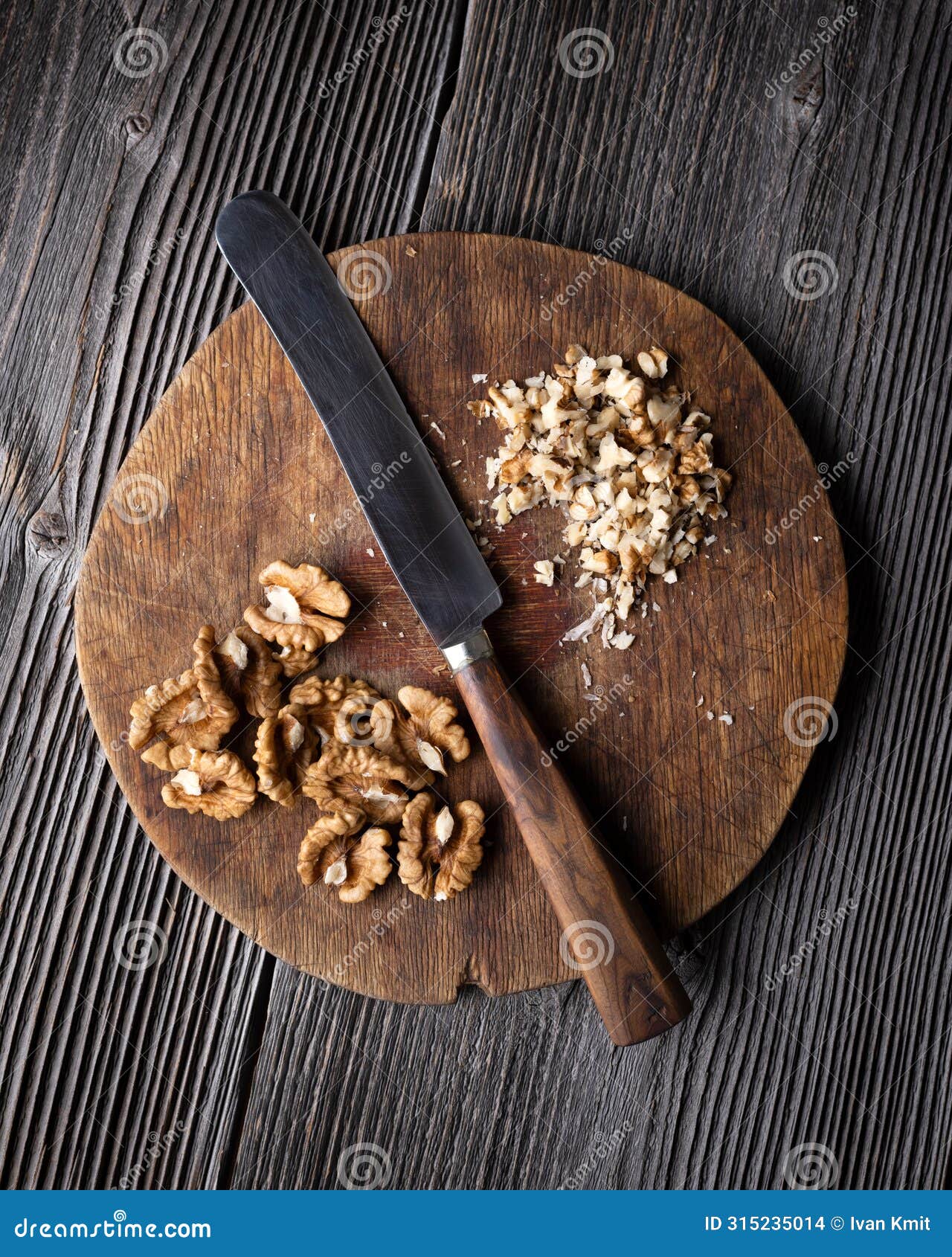 chopped walnuts and knife on wooden plate