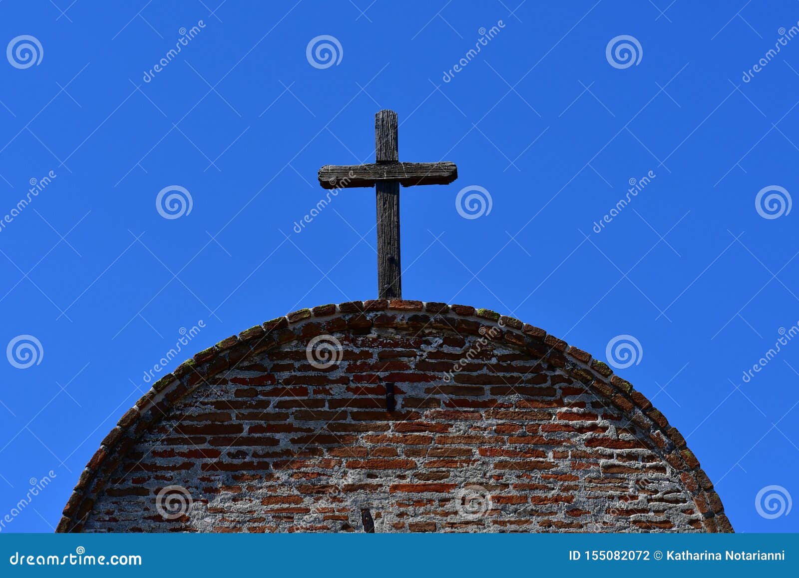 wooden cross against the blue sky on roof