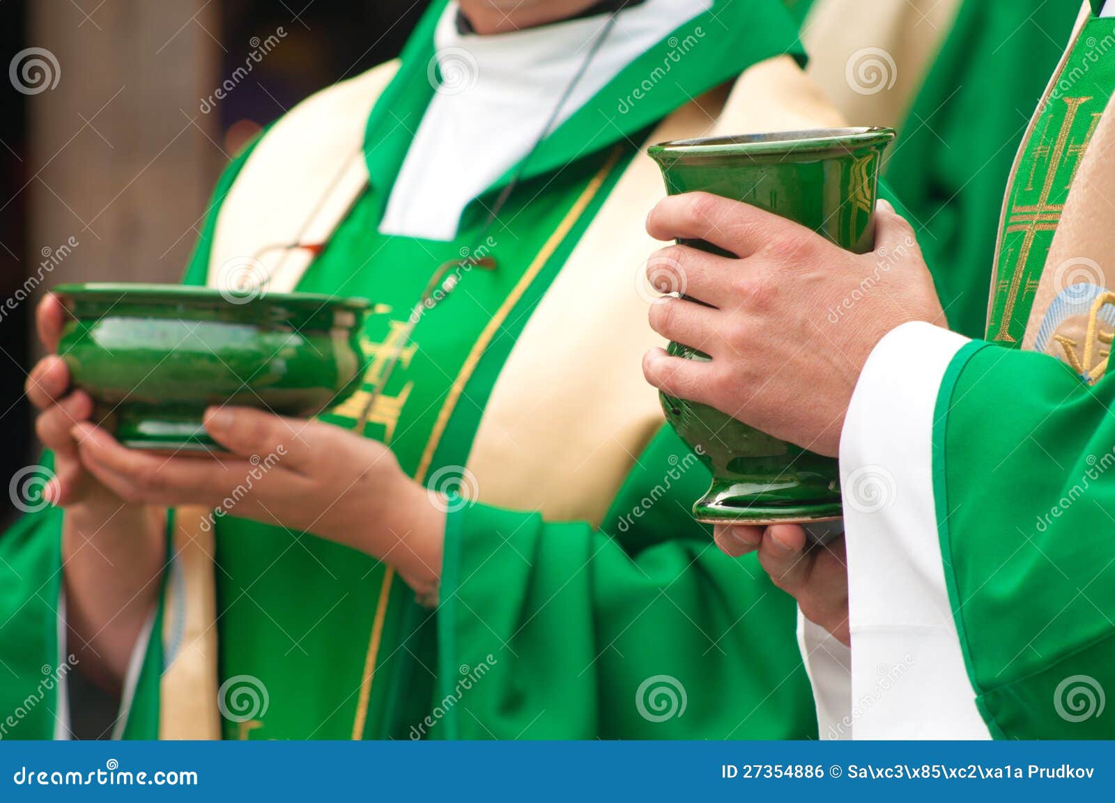 christian priests holding bowls of wafer and wine