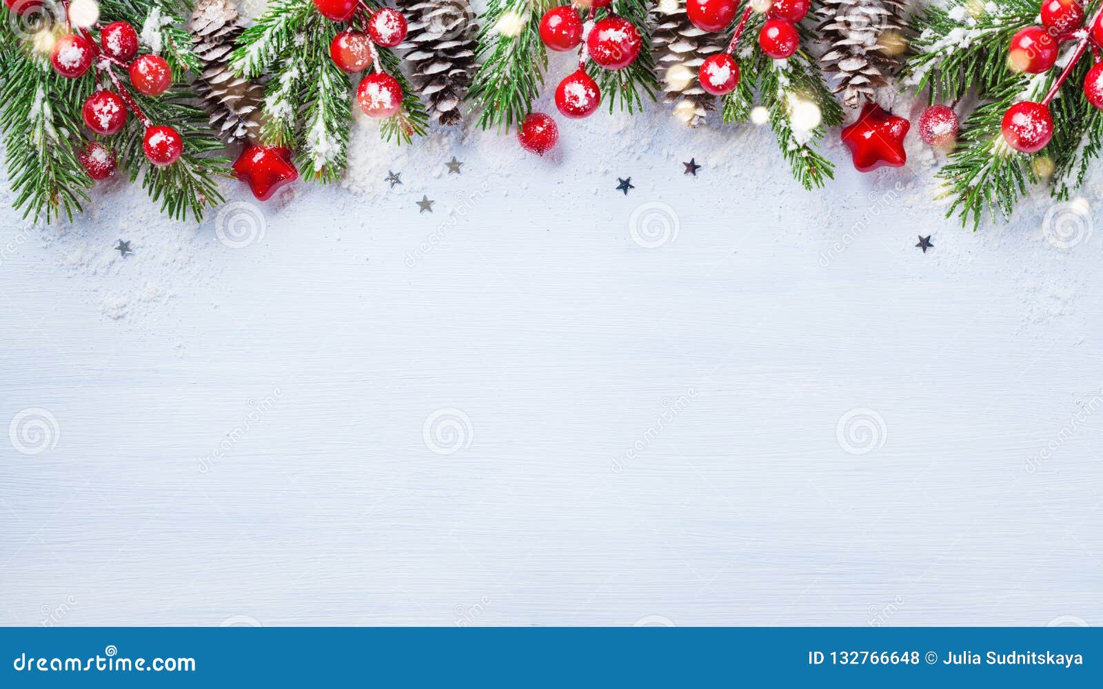 christmas background with snowy fir branches, cones and bokeh lights. holiday banner or card