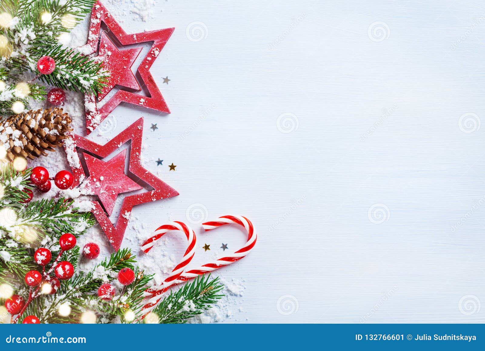 christmas background with stars, snowy fir branches, cones and bokeh lights. holiday banner or card