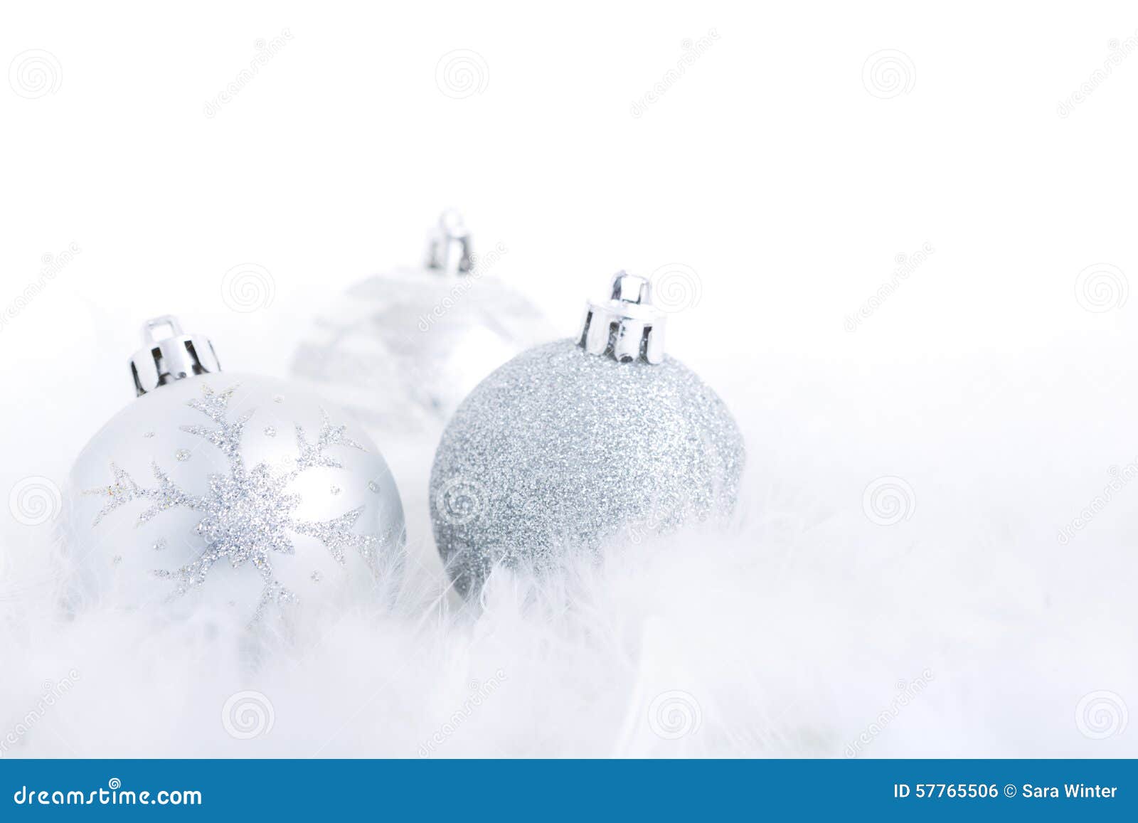 christmas baubles on a feathery surface, brightly lit