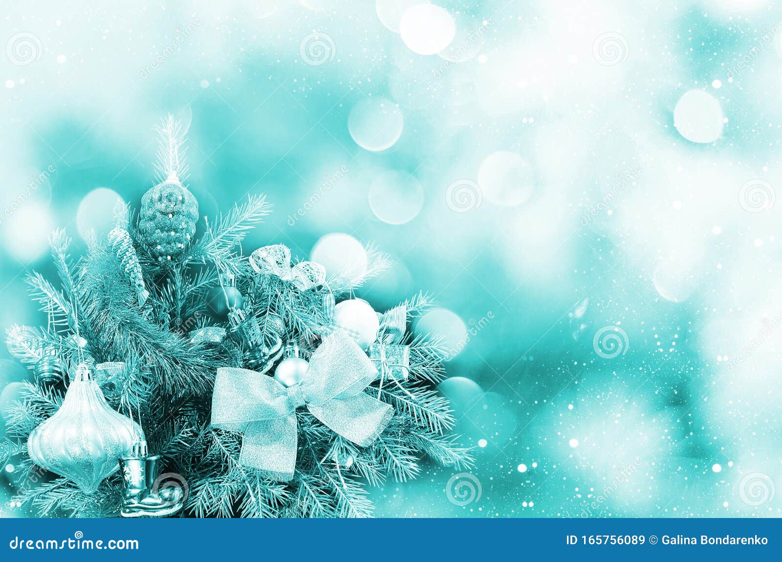 christmas bokeh background with decorated spruce branch. tinted in aqua mente