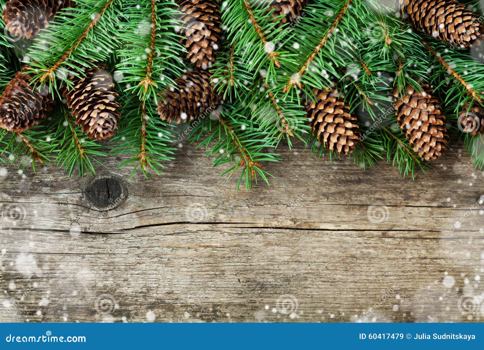 christmas decoration of fir tree and conifer cone on textured wood background, magic snow effect