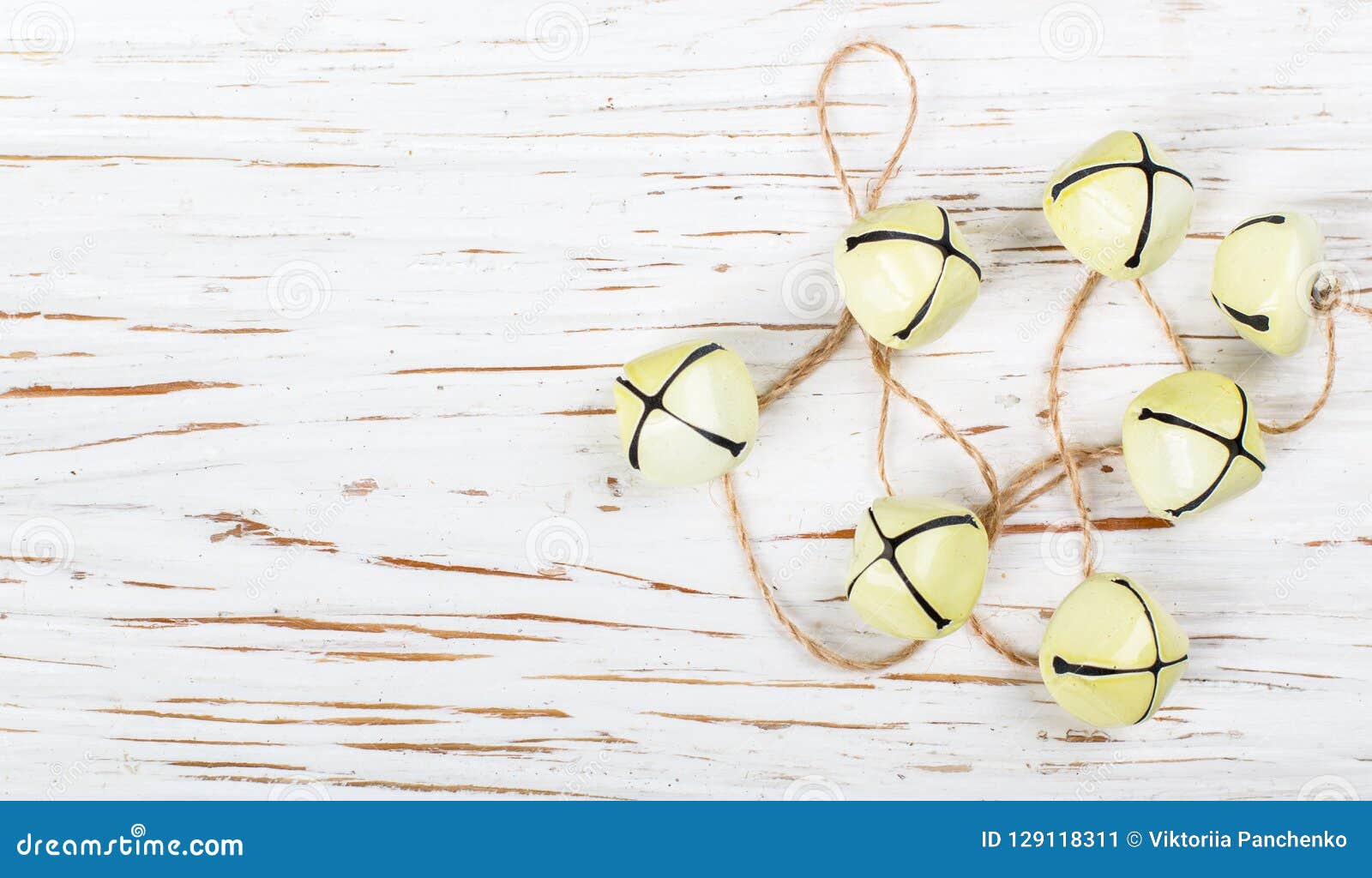 christmas decoration-yellow jingle bells on the old white table