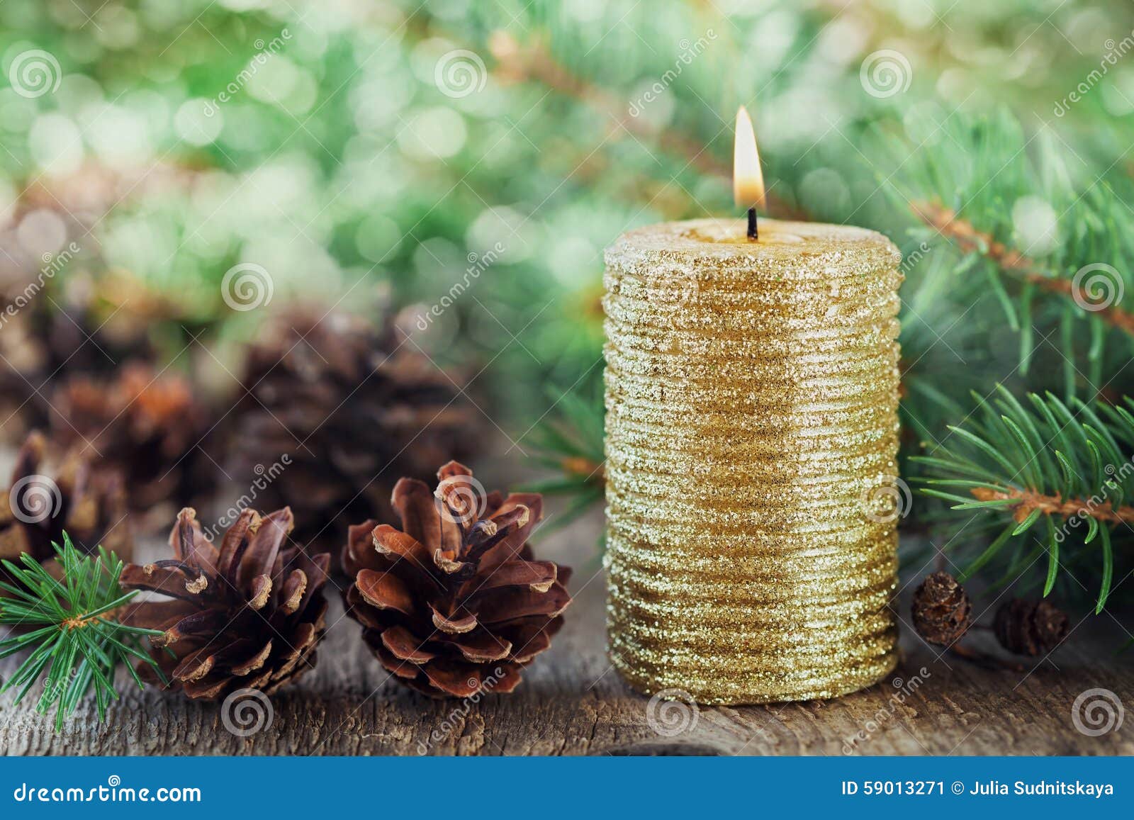 christmas decorations with lighted candle, pine cones and fir branches on wooden background with magic bokeh effect, christmas car