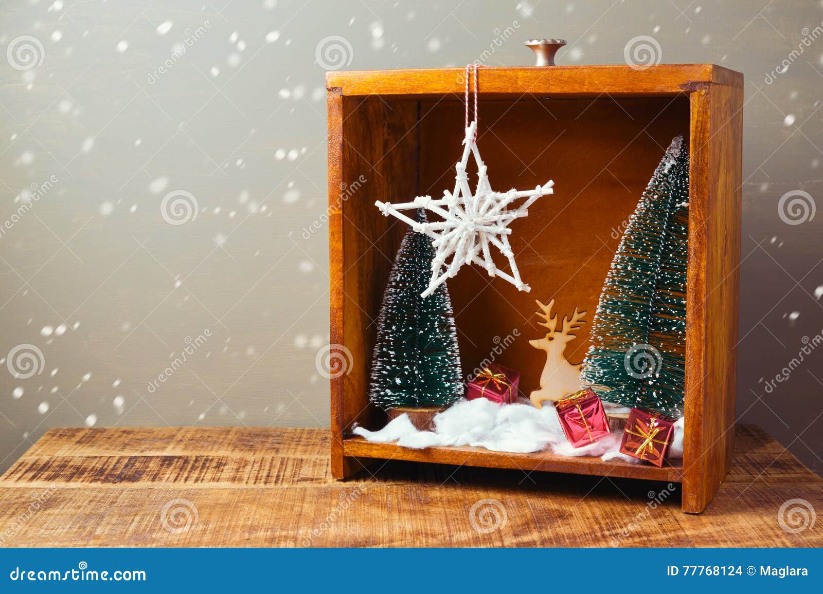 christmas diorama with pine trees and decorations on wooden table