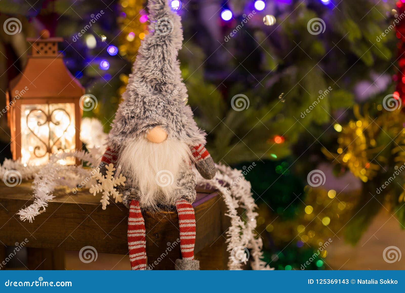 Christmas Elf on a Wooden Bench and Christmas Tree on Background Stock ...