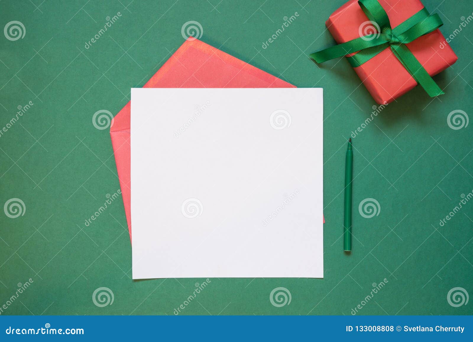 Christmas empty blank letter to Santa or invitation with giftbox on green. Top view with copy space