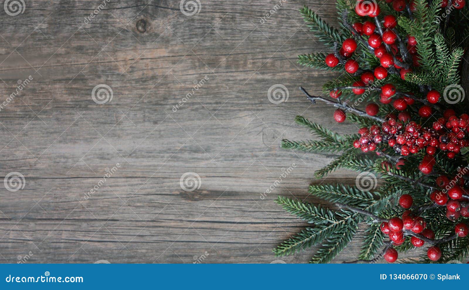 christmas evergreen branches and berries over rustic wood horizontal background