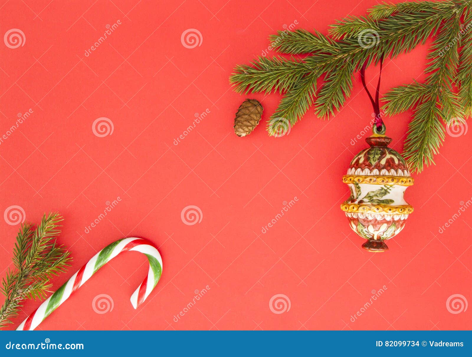 christmas frame on red background. green fir branches, xmas decoration and candy cane. top view, flat lay. copy space