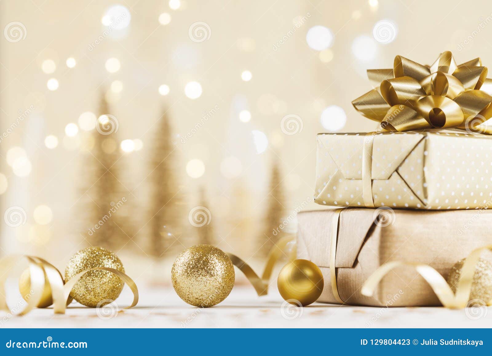 christmas gift box against golden bokeh background. holiday greeting card.