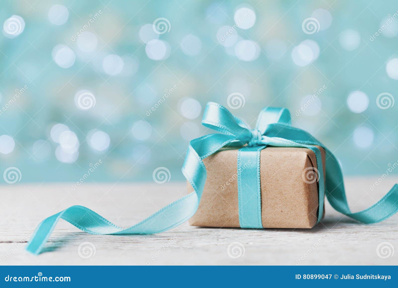 christmas gift box against turquoise bokeh background. holiday greeting card.