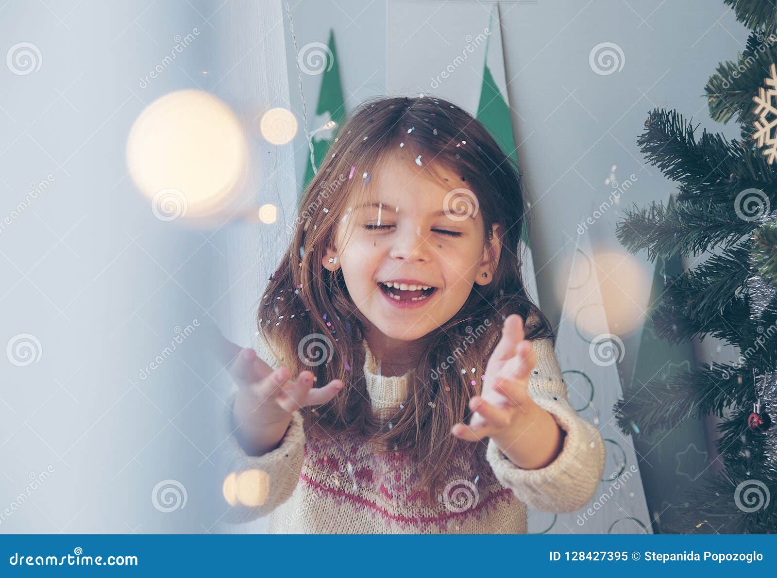 Merry Christmas! Happy Little Girl Throws Sparkles Near the Christmas ...