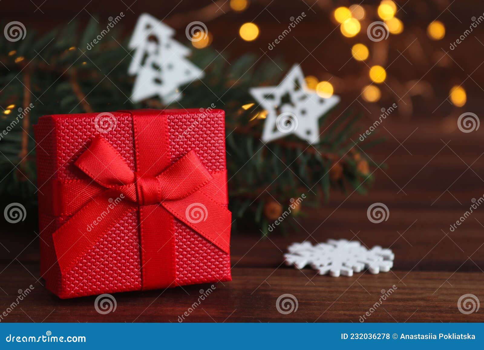 christmas greeting caed with gift box, christmas decorations, christmas tree branches, and bokeh. close-up, selective