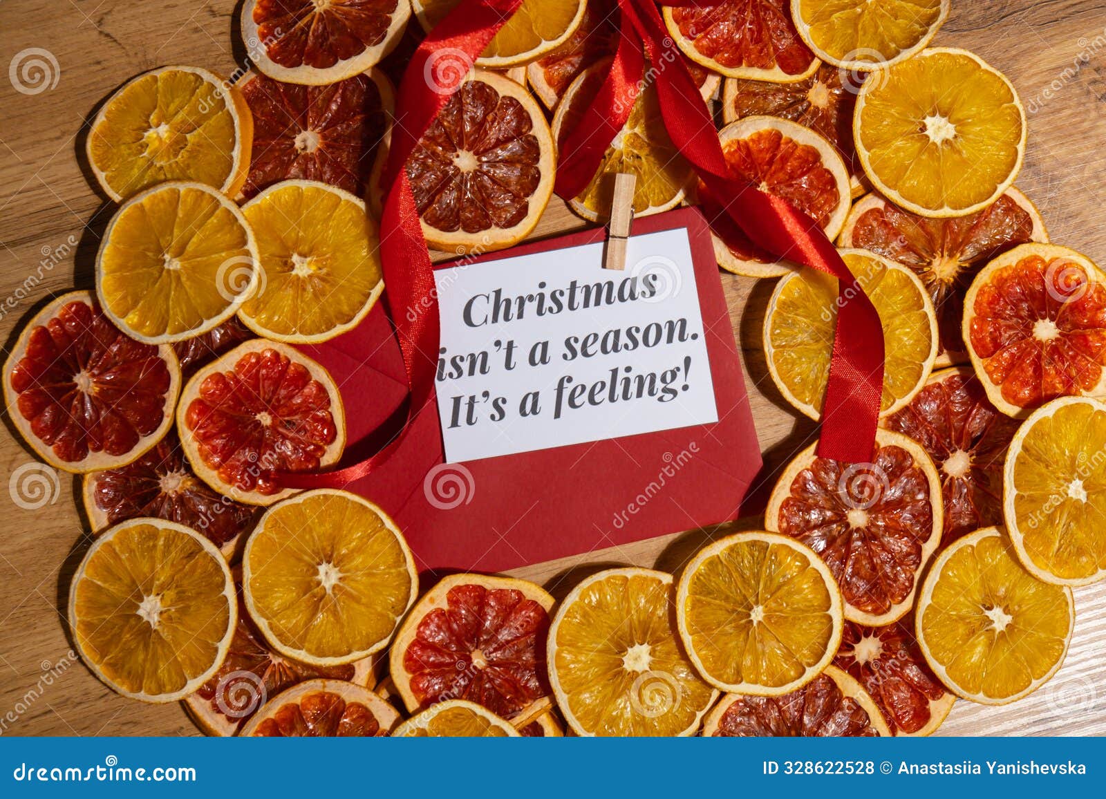 christmas handmade wreath made of dried slices of orange and grapefruit with red envelope and paper note with