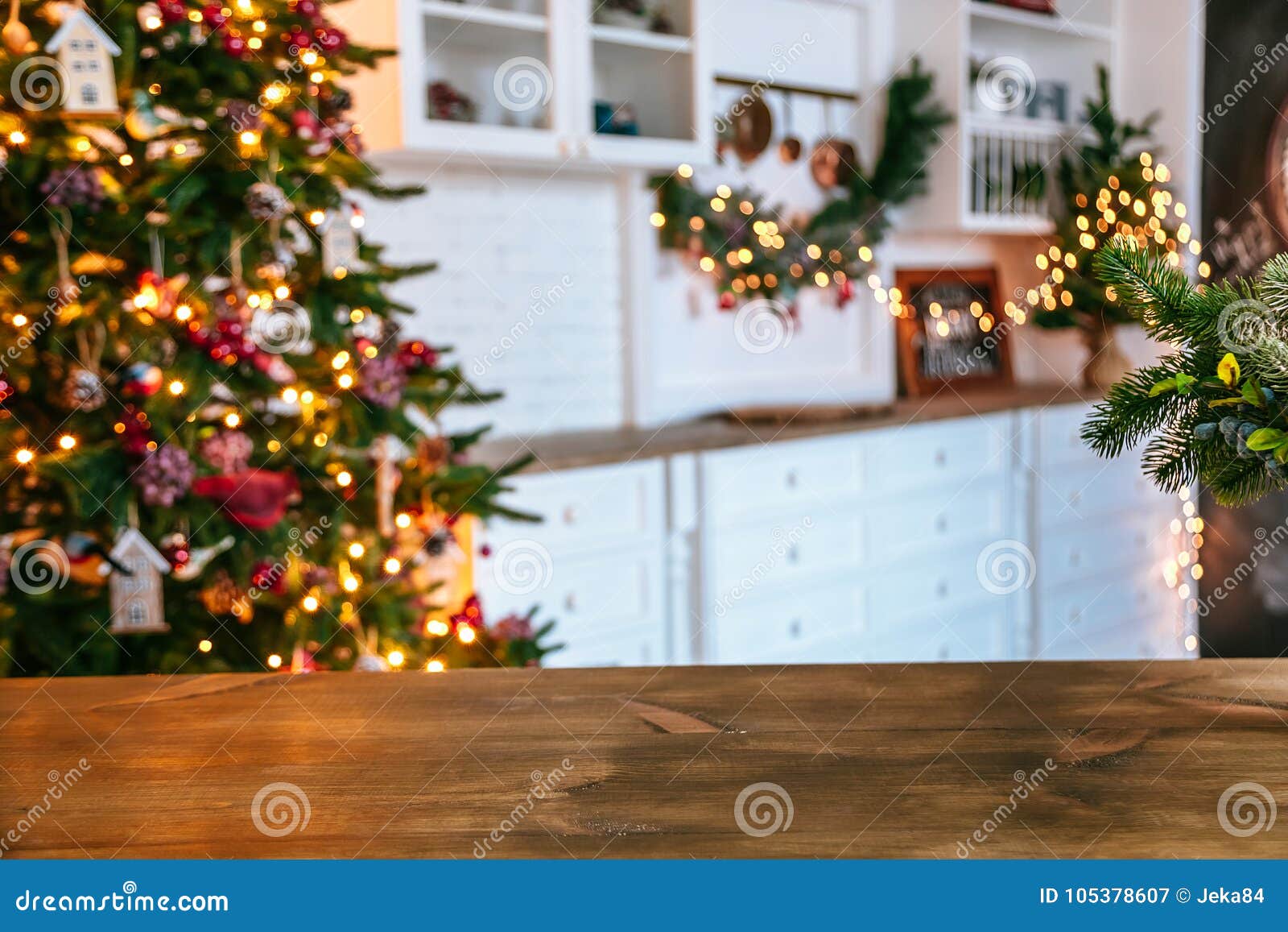 christmas holiday background with empty rustic table and the bokeh of the living room with the christmas tree on the second plan