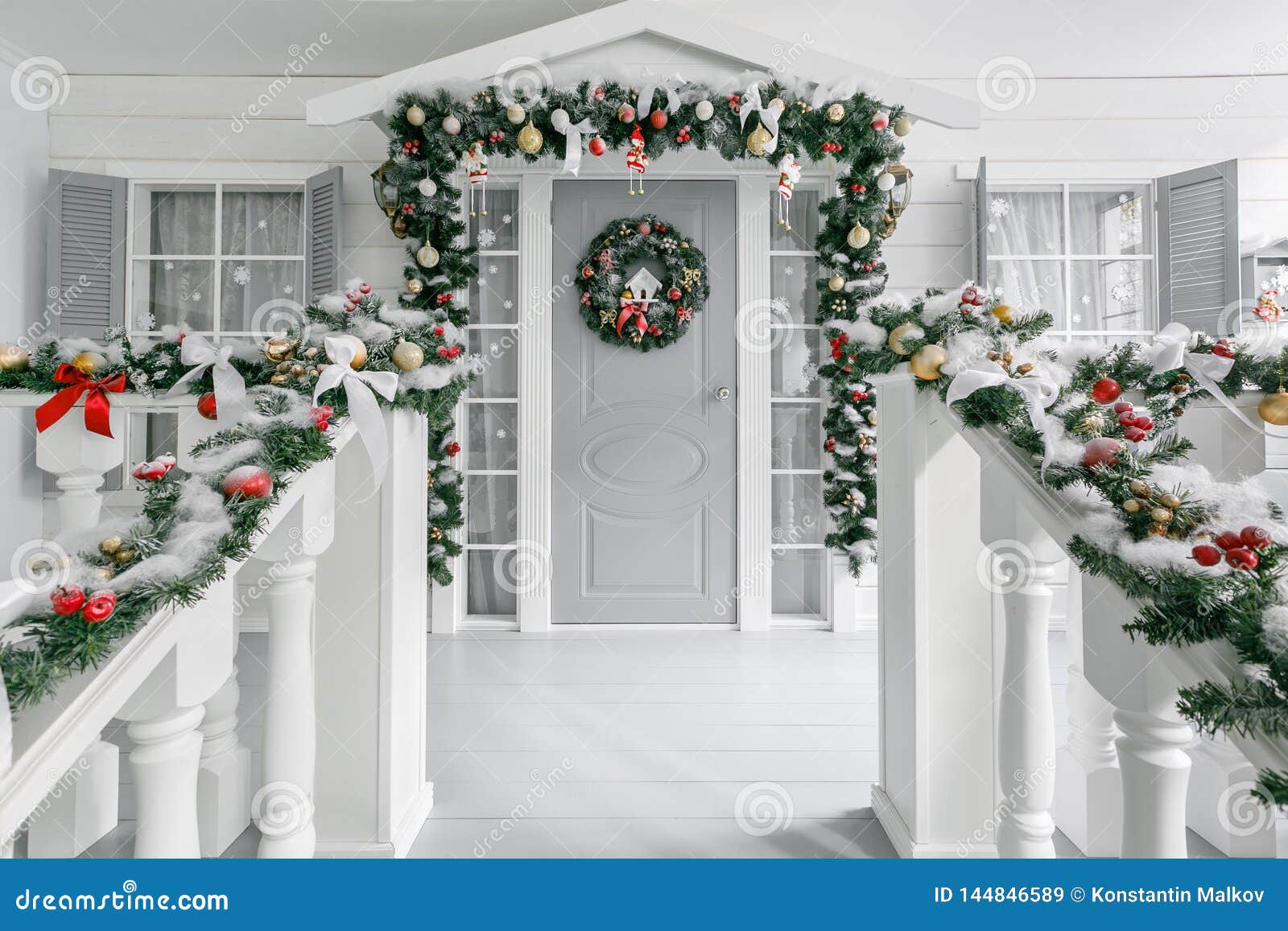 christmas morning. porch a small house with a decorated door with a christmas wreath. winter fairy tale.