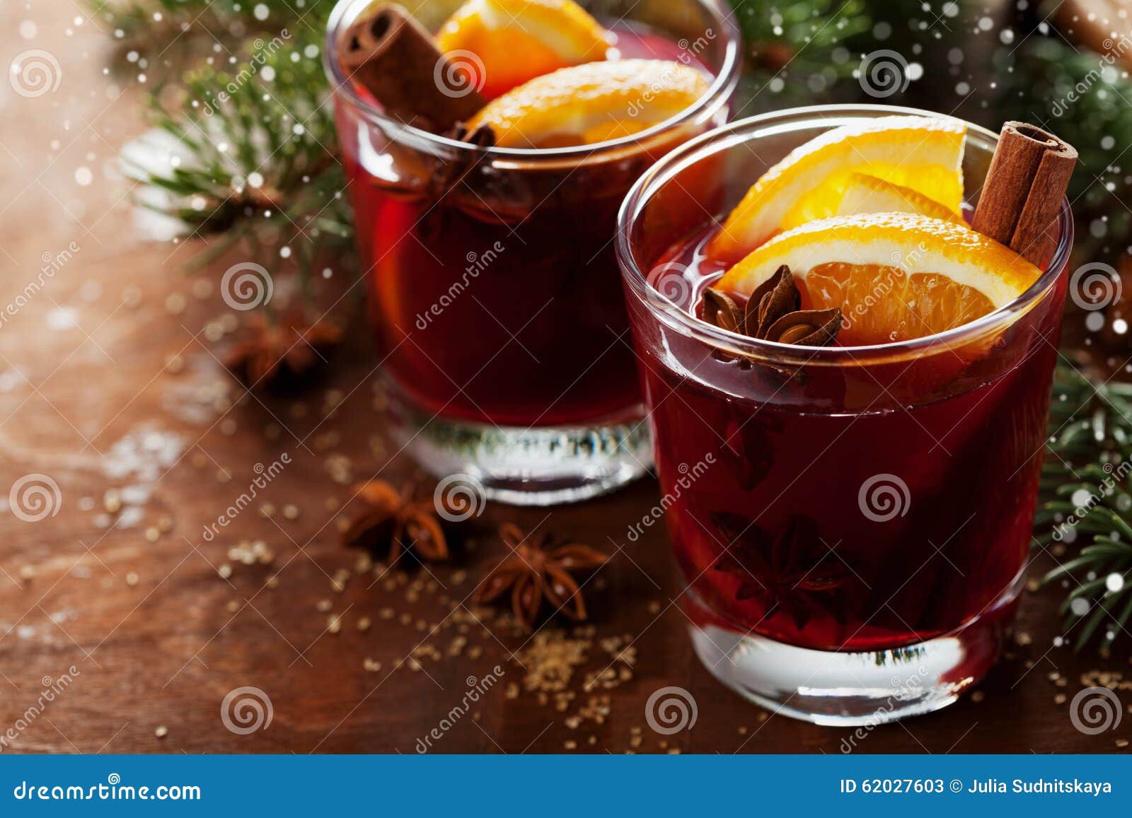 christmas mulled wine or gluhwein with spices and orange slices on rustic table, traditional drink on winter holiday, magic light