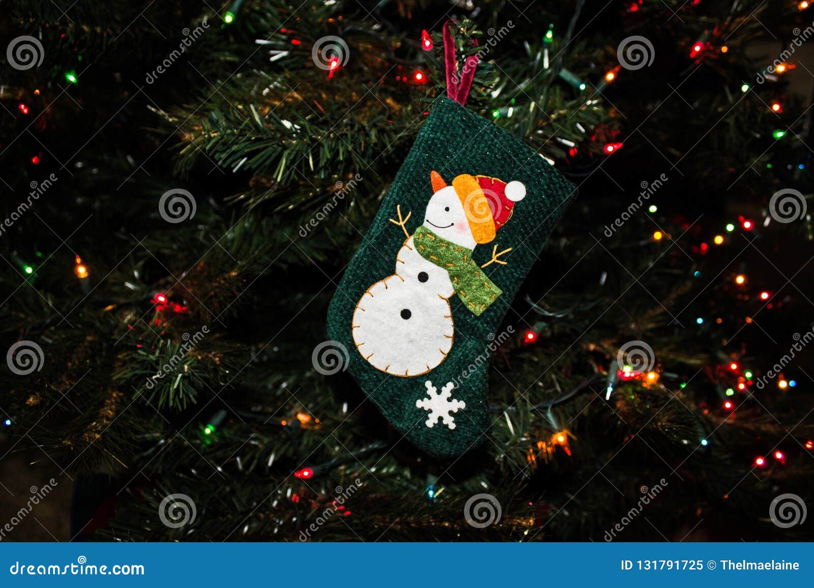 Christmas Ornament of a Snowman on a Stocking on an Evergreen Tree ...